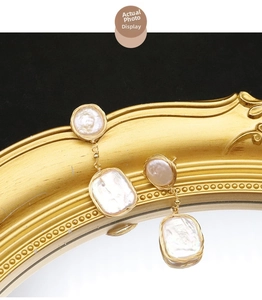 Macro view of baroque pearls with handmade gold wire wrapping on vintage studs