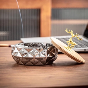 Zinc alloy ashtray with geometric facets, wooden lid and golden deer handle detail