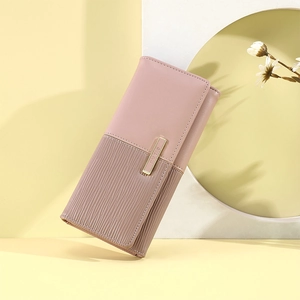 Detail of dusty pink patchwork wallet featuring textured pleats and golden metal hardware