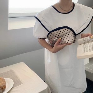 Detailed view of a semi-transparent mesh makeup bag featuring black heart patterns