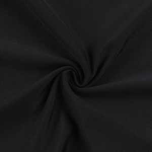 Close-up of black knitted lace fabric with a spiral fold showing fine textile texture