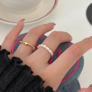 Macro shot of 925 silver wave ring and baroque pearl ring set worn on finger