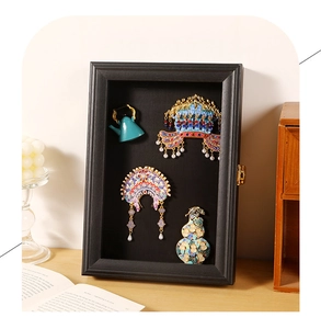 Detail of a black shadow box display case featuring traditional miniature Chinese crafts