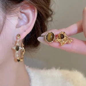 Tiger eye stone earrings and ring set in vintage gold finish worn by a model