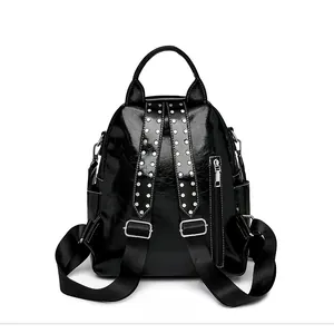 Detail of the black glossy backpack back with rivet straps and hidden zipper pocket