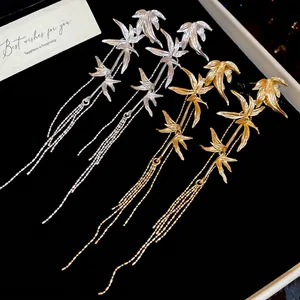 Elegant bamboo leaf tassel drop earrings in gold and silver metal with brushed finish