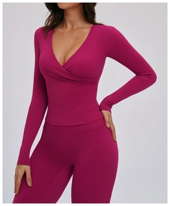 Detail of slim fit magenta yoga set featuring a cross V-neck long sleeve top and leggings