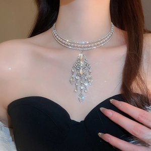 Detail of multi-layer pearl choker with crystal tassel pendant for evening wear