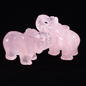 Macro detail of two hand-carved pink quartz elephant figurines with natural crystal textures