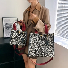 Detailed comparison of large and small leopard print canvas tote bags with red straps