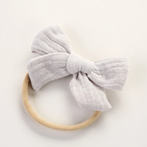 Détail du bandeau en mousseline de coton gris avec nœud et ruban élastique en nylon