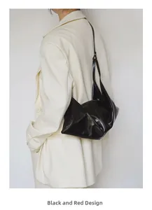 Detail of minimalist black patent leather crescent bag with smooth zipper closure