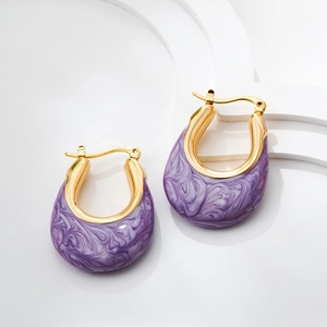 Macro detail of U-shaped gold hoop earrings with purple marble enamel inlay texture