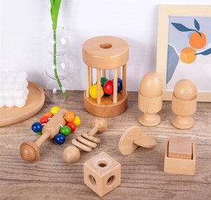 Eight-piece set of wooden Montessori baby rattles and teething blocks on a wooden surface