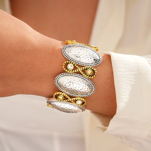 Gros plan du bracelet bicolore martelé avec détails tissés dorés et strass brillants