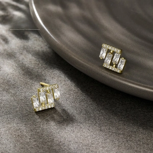 Macro shot of gold geometric stud earrings with rectangular cubic zirconia in modern style