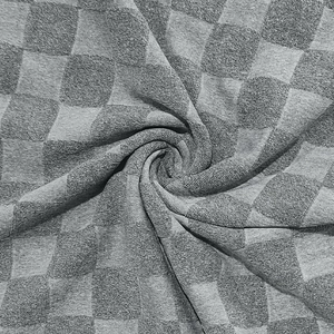 Close-up of grey polo shirt fabric featuring a soft jacquard checkered knit texture