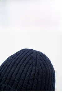 Detail of dark blue knit winter hat showing thick ribbed texture and thermal material