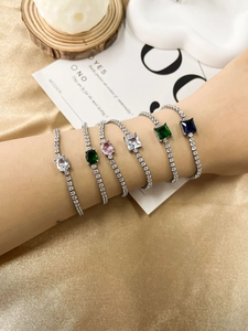 Detail of stacked tennis bracelets with colorful oval and square-cut zircon stones