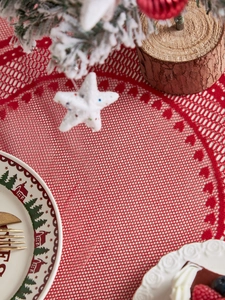 Close-up of red lace Christmas tablecloth featuring heart-shaped hollow embroidery pattern