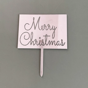 Vue détaillée du cake topper en acrylique avec texte Merry Christmas gravé au laser.