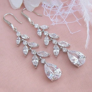 Elegant silver leaf tassel earrings with teardrop zircon on pink satin background
