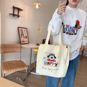Detailed close-up of cute dog embroidery and HAPPY slogan on beige canvas tote bag