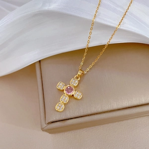 Elegant gold cross necklace with pink crystal and micro-pave diamonds on silk fabric