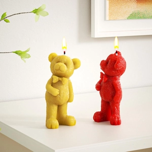 Makro-Detail von strukturierten Bärenkerzen mit Schleifen und leuchtenden Flammen