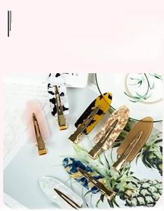 Detailed view of colorful tortoiseshell acrylic hair clips with golden metal bases