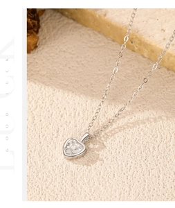 Gros plan du pendentif cœur en diamant argent S925 sur une surface en pierre texturée