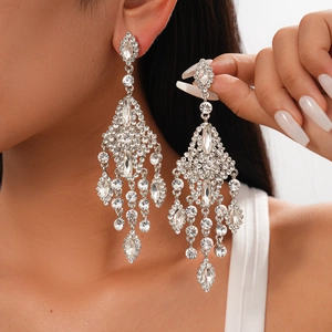 Close-up of sparkling rhinestone tassel chandelier earrings worn for size comparison