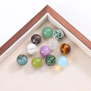 Detailed view of 11 assorted 16mm natural crystal and gemstone spheres on a wooden tray