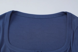 Gros plan sur le col carré et la texture côtelée de ce t-shirt en tricot bleu marine