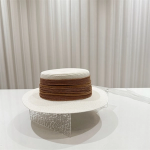 Detail of white boater straw hat with elegant brown pleated ribbon for sun protection