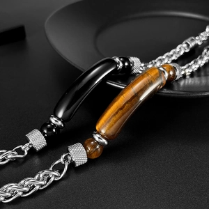 Macro detail of stainless steel bracelets featuring tiger eye and black stone inlays
