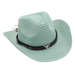 Detail of mint green straw cowboy hat featuring brown leather band and silver bull head