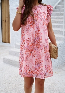 Détail d'une robe fleurie rose avec des manches courtes à volants et une coupe au genou