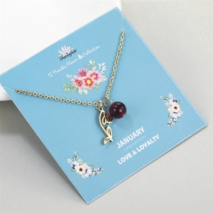 Close-up of gold stainless steel necklace with garnet red bead and January flower card