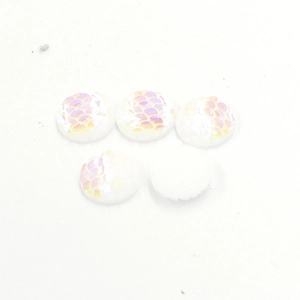 Macro detail of white round resin cabochons with iridescent rainbow fish scale patterns