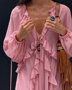 Detail eines rosa Chiffonkleides mit eleganten Rüschen und brauner Fransen-Handtasche