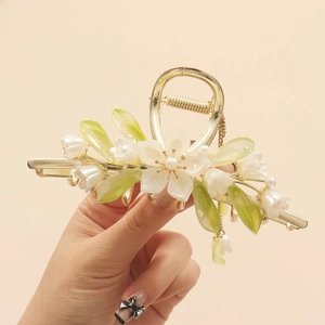 Detailed macro view of golden lily of the valley hair claw with hanging tassels