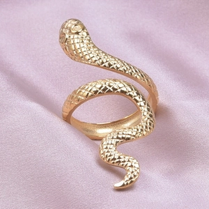Vue macro détaillée d'une bague serpent dorée réglable sur un tissu de soie élégant