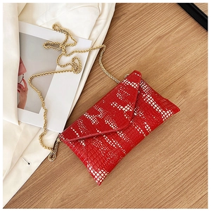 Detail of red envelope bag with white geometric patterns and golden chain strap