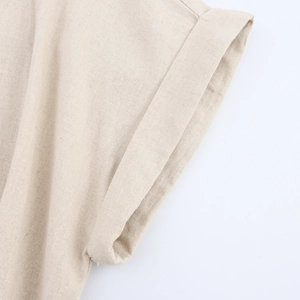 Close-up of rolled sleeve detail and beige linen texture on a button-down dress