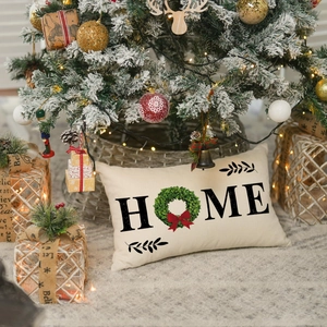 Linen Christmas pillow cover with HOME print and green wreath on a festive background