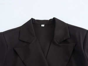 Detail of classic notched lapel and size S label on a black double-breasted blazer coat