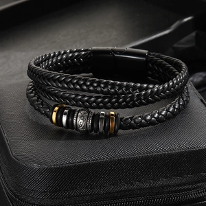 Detail of multi-layer leather braided bracelet with metal beads on a black gift box