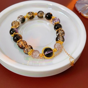 Macro detail of vintage beaded bracelet with purple glass beads and golden lotus charms