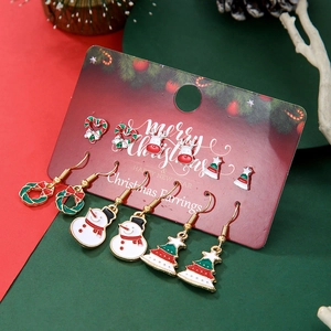 Close-up of festive Christmas earring set with snowman, reindeer and tree motifs on cards